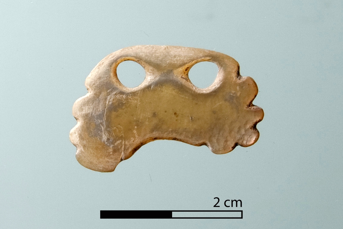 Mother-of-pearl pendant, from a pit in Unit E. It is a unique piece in Monjukli Depe.
