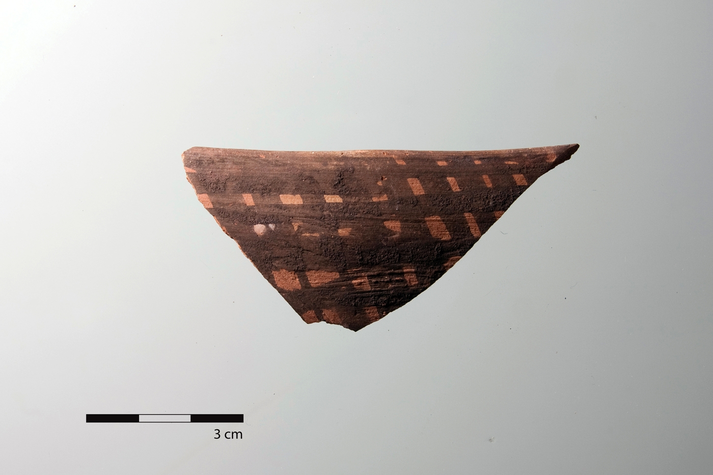 Randscherbe eines bemalten Gefäßes der Meana Black on Red-Ware mit einer grob aufgetragenen Kreuzschraffur.