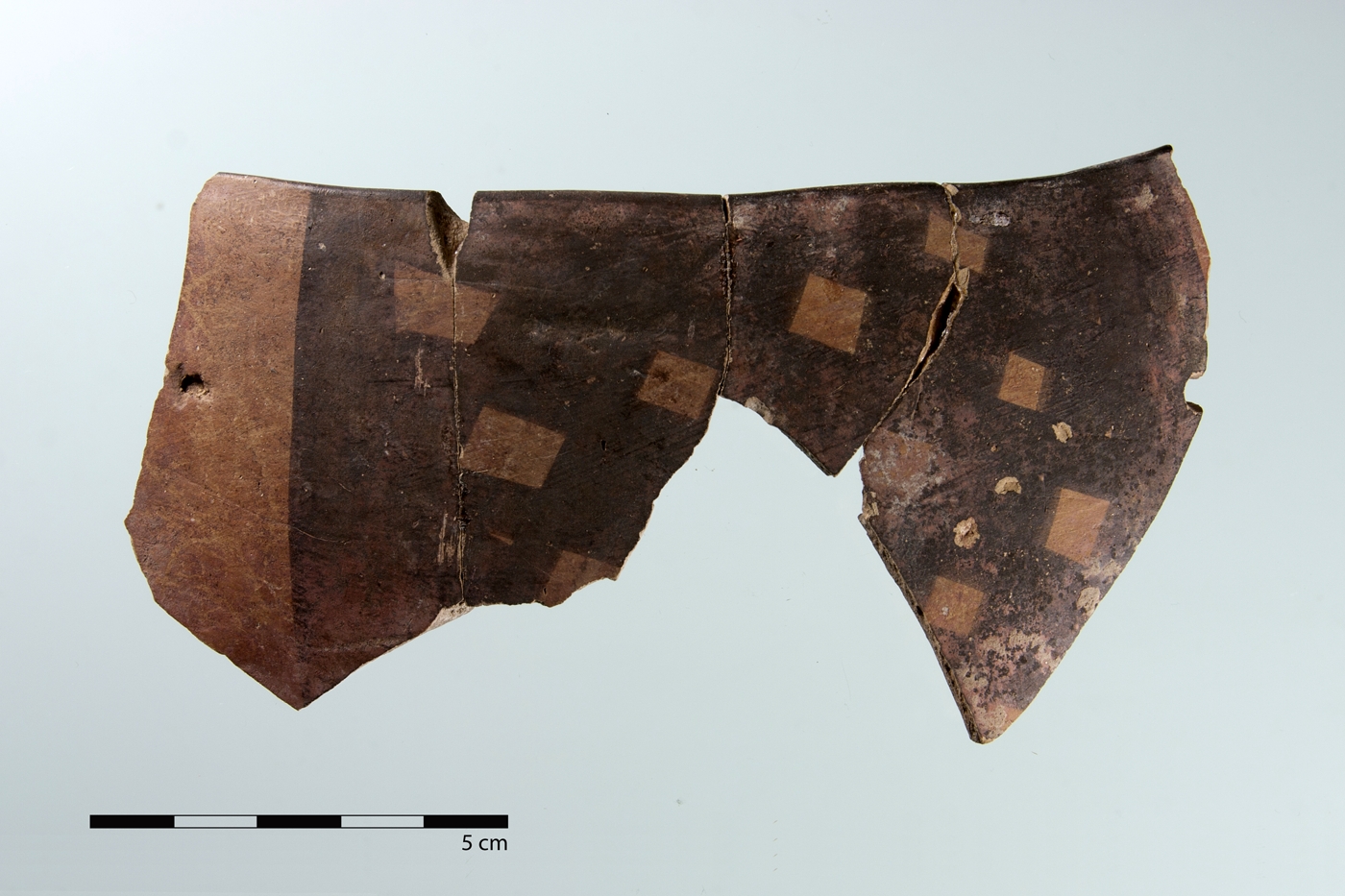 Randscherbe eines bemalten Gefäßes der Meana Black on Red-Ware mit dicker Kreuzschraffur, die ein Rauten-Motiv erkennen lässt.