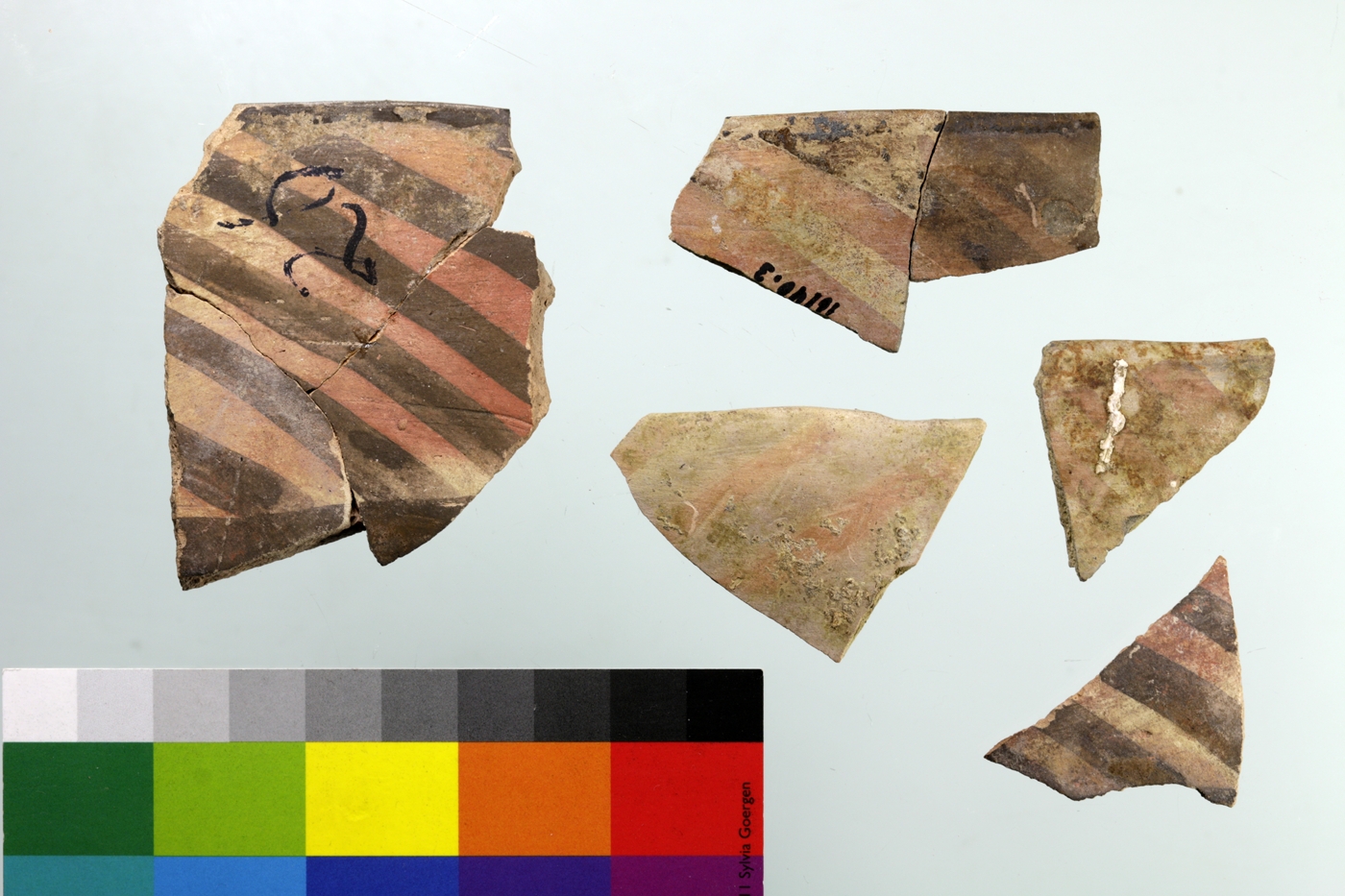 Meana Black on Red sherds painted with oblique stripes. The lighter colors are the result of overfiring.
