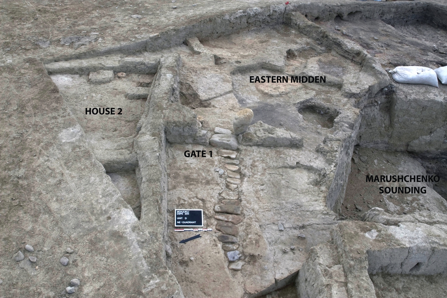 The location of the Eastern Midden in relation to Gate 1 and the partially paved street leading up to the gate. House 2 borders the street on its north side. The deep sounding excavated by A. Marushchenko is visible on the righthand portion of the picture.