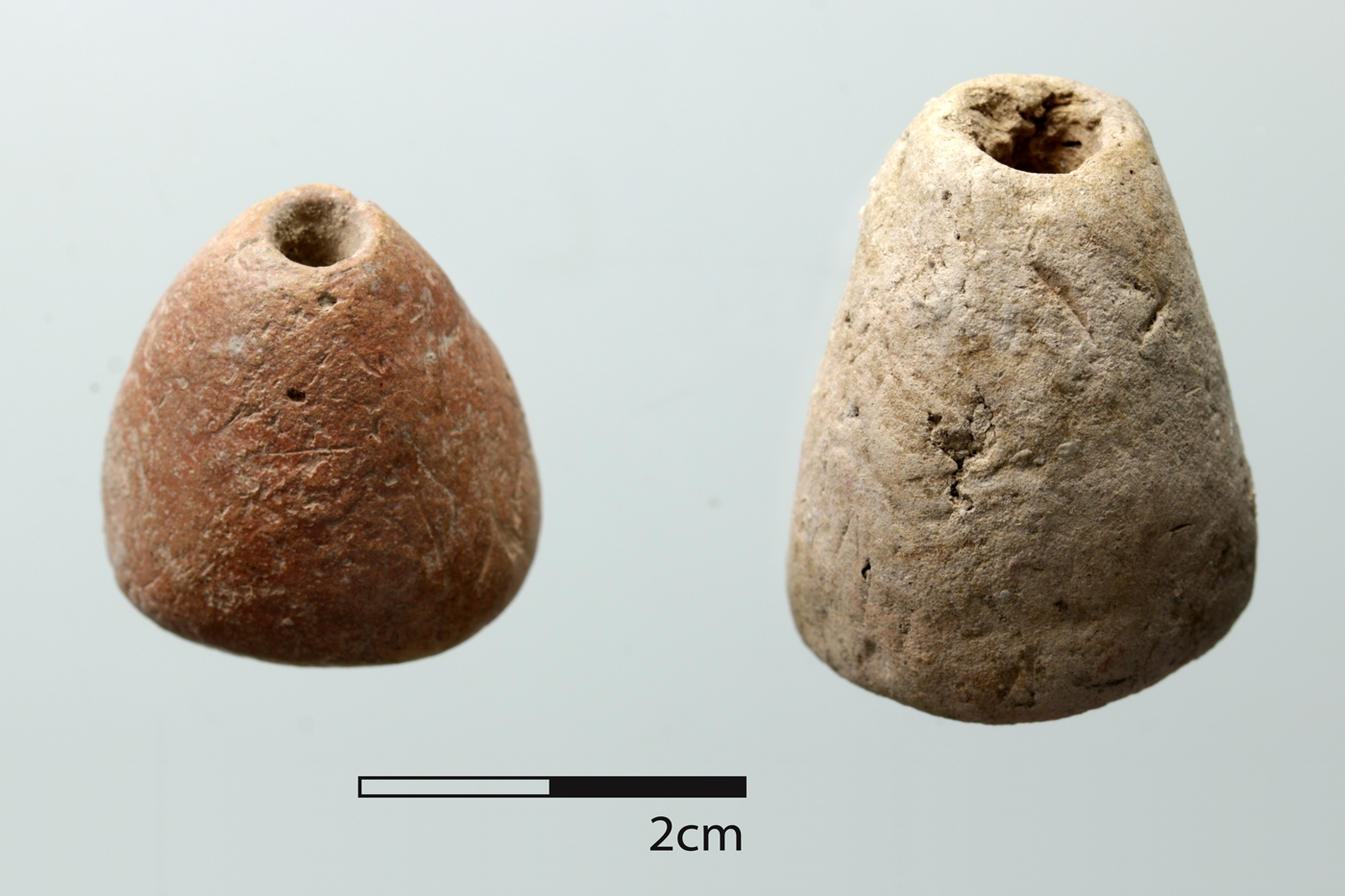 Two conical spindle whorls showing differences in size, overall form, and color